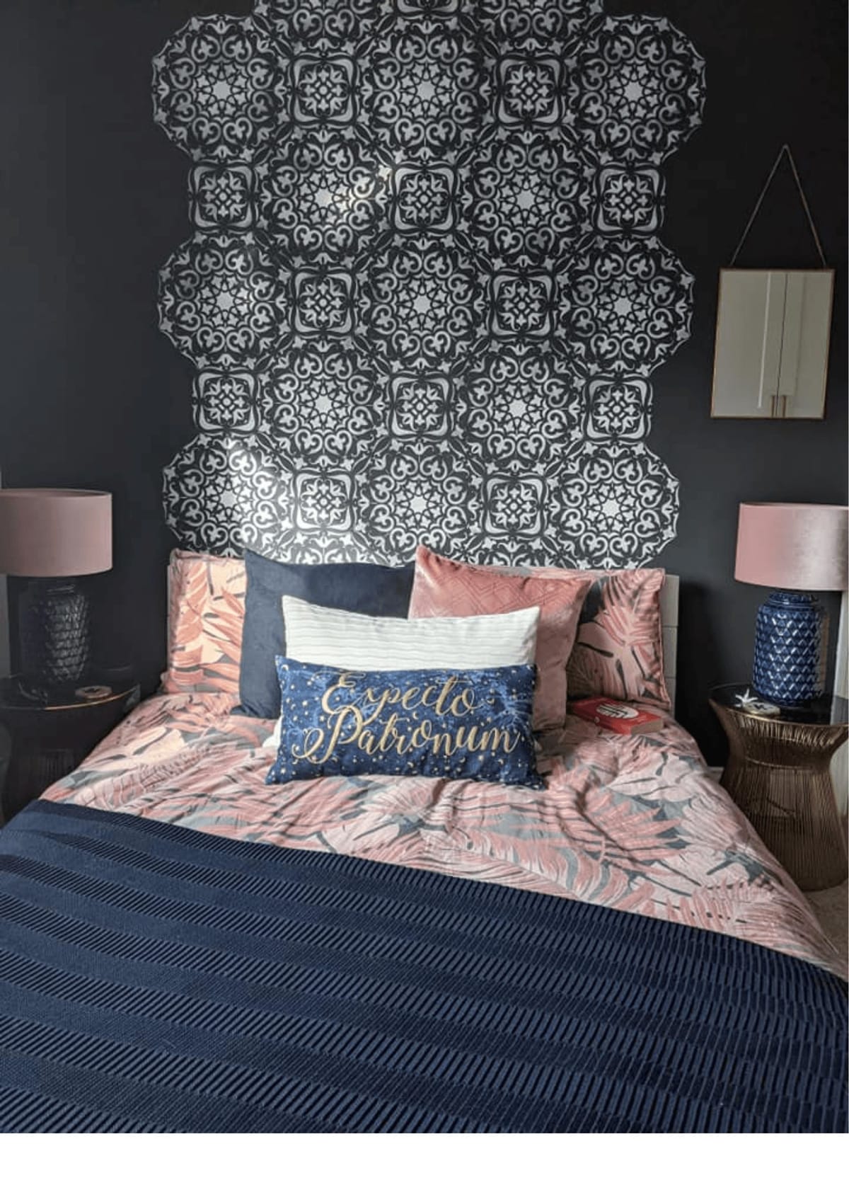 Bedroom with a patterned stencil headboard wall and pink bedding