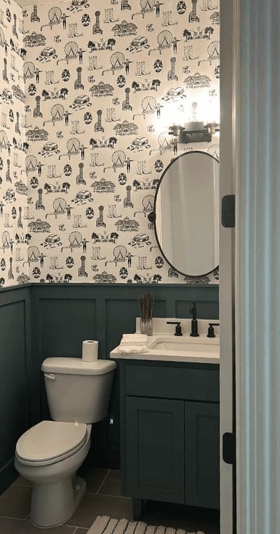 Cloakroom with patterned wallpaper, green vanity and round mirror