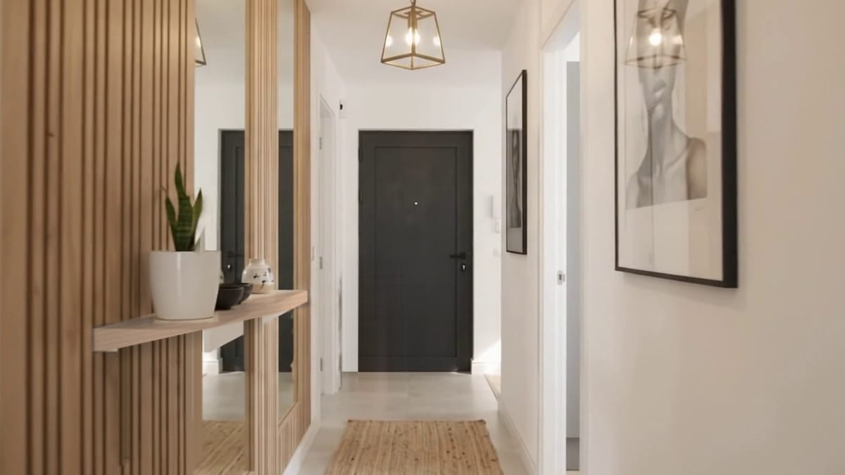 Bright hallway with oak slats, framed prints and a charcoal front door