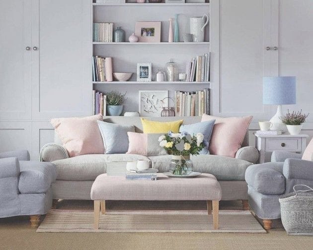 Pastel living room with a grey sofa, pink cushions and built-in shelving